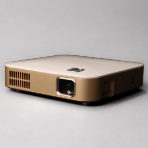 Gold and white Kodak Luma 350 portable projector, viewed from the front and side.